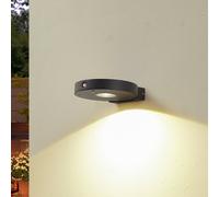 Aplique de pared LED solar Lucande Tavon, redondo, negro, sensor