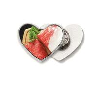 Broche de metal con forma de corazón y pata de cordero con textura de carne cruda