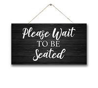 Letrero de madera manchado con texto en inglés «Please Wait to Be Seated Doctors Offictors»