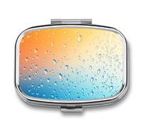 Pastillero con gotas de agua sobre fondo degradado azul y naranja, pastillero de 2 compartimentos, organizador de pastillas de viaje para bolso de bolsillo