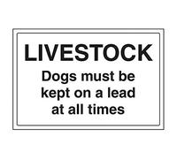 Señal agrícola en inglés de VSafety Signs (76031BA-R), con lema «Livestock/Dogs Must Be Kept On A Lead At All Times»; plástico rígido, horizontal, 300 x 200 mm en color negro