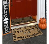 Un felpudo mágico con la inscripción 'THE WITCH IS IN', de material de felpa con una grosor de 0.4 pulgadas y un peso de 580 gramos. Tiene una base marrón con negra y diseño de , para Halloween.